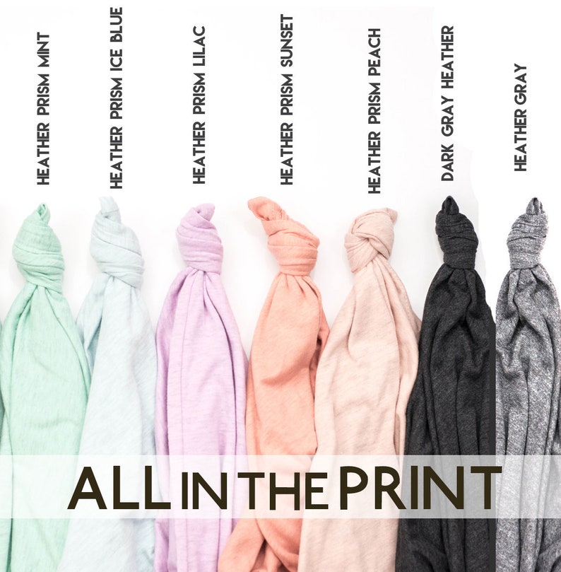 Puede incluir: Primer plano de ocho camisetas de diferentes colores, todas dobladas y anudadas. Las camisetas est&aacute;n etiquetadas con sus nombres de color: Heather Prism Mint, Heather Prism Ice Blue, Heather Prism Lilac, Heather Prism Sunset, Heather Prism Peach, Dark Grey Heather y Heather Grey. El texto "ALL IN THE PRINT" est&aacute; impreso debajo de las camisetas.