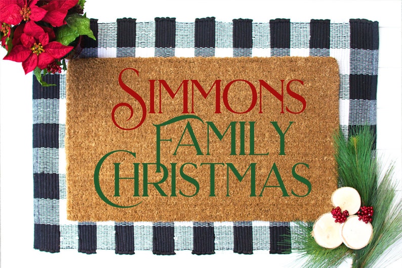 Puede incluir: Una alfombra de coco marr&oacute;n con el texto "Simmons Family Christmas" en letras rojas y verdes. La alfombra est&aacute; sobre una alfombra a cuadros negros y blancos.