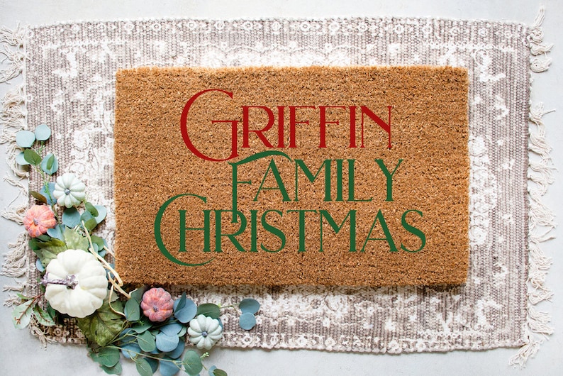 Puede incluir: Una alfombra de coco marr&oacute;n con el texto "GRIFFIN FAMILY CHRISTMAS" en letras verdes y rojas.