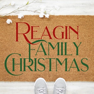 Puede incluir: Una alfombra de coco marr&oacute;n con el texto "Reagin Family Christmas" en letras rojas y verdes.