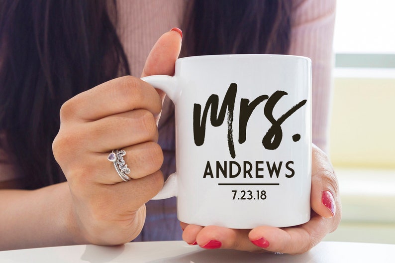 May include: White ceramic mug with black text that reads "Mrs. Andrews 7.23.18".