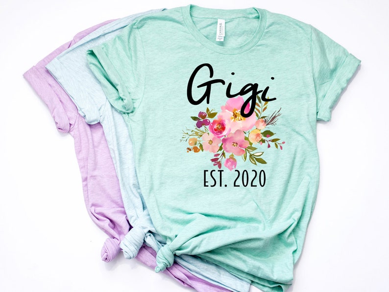 May include: A light green t-shirt with a floral design and the text "Gigi Est. 2020".