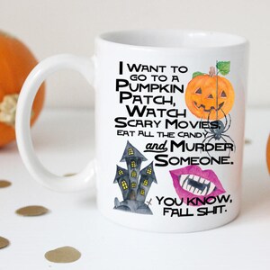 May include: White ceramic mug with a black and white illustration of a haunted house, a pumpkin, a spider, and a pair of lips with fangs. The text on the mug reads "I want to go to a pumpkin patch, watch scary movies, eat all the candy and murder someone. You know, fall shit."