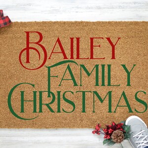 Puede incluir: Una alfombra de coco marr&oacute;n con el texto "Bailey Family Christmas" en letras rojas y verdes.
