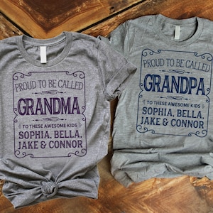 May include: Two gray t-shirts with a vintage-style design. The text on the shirts reads "Proud to be called Grandma" and "Proud to be called Grandpa". Both shirts list the names "Sophia, Bella, Jake & Connor" underneath the main text.