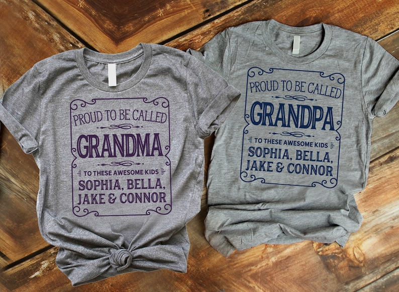 May include: Two gray t-shirts with a vintage-style design. The text on the shirts reads "Proud to be called Grandma" and "Proud to be called Grandpa". Both shirts list the names "Sophia, Bella, Jake & Connor" underneath the main text.