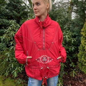May include: A red vintage jacket with a zipper closure and a drawstring waist. The jacket has an embroidered design on the front that says "Silence of the Soul".