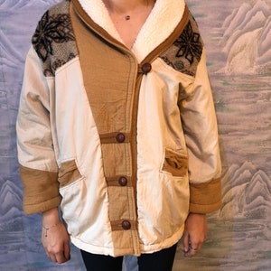 May include: A cream-colored jacket with brown corduroy accents and a sherpa collar. The jacket has a button closure and two pockets.