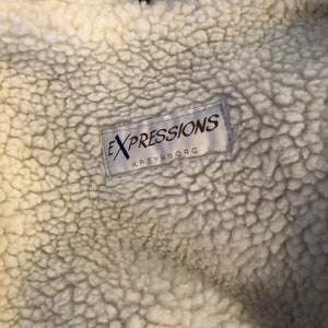 May include: White faux fur lining with a white label that reads "EXPRESSIONS KREYMBORG" in black text.