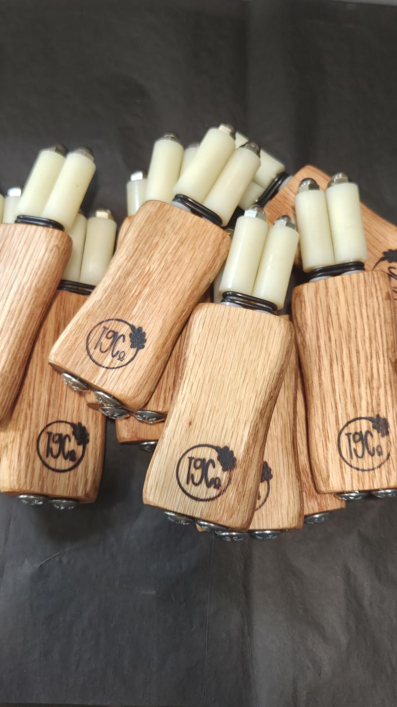 May include: A collection of wooden tools with light-colored grain, each featuring a branded logo with the text 19C and a small leaf icon. Each tool has two white cylindrical rollers attached to the top with metal hardware and black springs.