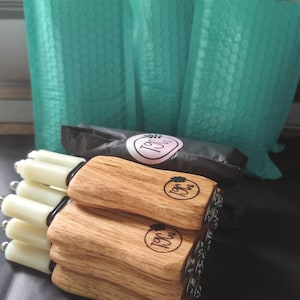 May include: A stack of four handheld tools with light-colored wooden handles and white cylindrical tips. Each handle features a circular brand logo with the text T9C. The tools are arranged horizontally, with the wooden handles facing forward.