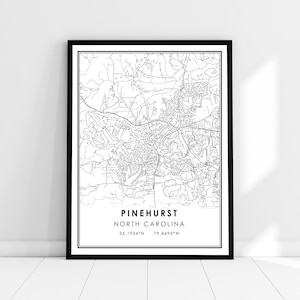 May include: Black and white line art map print of Pinehurst, North Carolina. The map shows the streets and roads of the town. The text "Pinehurst, North Carolina" and the coordinates "35.1954°N 79.4695°W" are printed below the map.