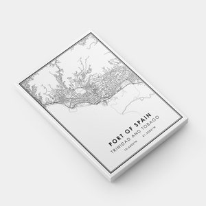 Puede incluir: Mapa de l&iacute;neas en blanco y negro de Puerto Espa&ntilde;a, Trinidad y Tobago. El mapa muestra las calles de la ciudad y la costa. El texto "PORT OF SPAIN TRINIDAD AND TOBAGO 10.6603&deg;N 61.5086&deg;W" est&aacute; impreso debajo del mapa.