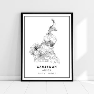 May include: A black and white map of Cameroon, Africa, with the country's name and coordinates printed below the map. The map is framed in a black frame and is hanging on a white wall.