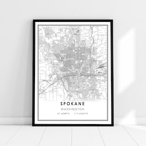 May include: Black and white line art map print of Spokane, Washington. The map shows the city streets and landmarks. The text "Spokane, Washington" and the coordinates "47.6588°N 117.4260°W" are printed below the map.