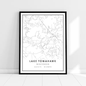 May include: A framed black and white map print of Lake Tomahawk, Wisconsin. The map features detailed line drawings of the lake and surrounding areas, with the lake's name, state, and coordinates displayed in a clean, modern font.