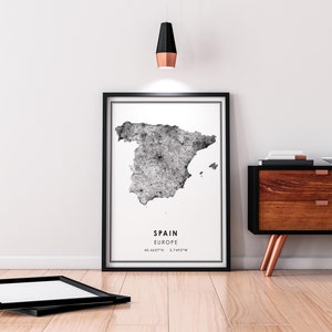 May include: Black and white print of a map of Spain with the text "SPAIN EUROPE 40.4637&deg;N 3.7492&deg;W" in a black frame.