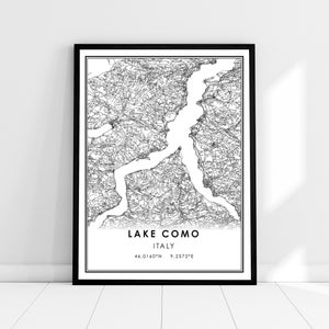 May include: Black and white line art map of Lake Como, Italy. The map shows the lake's shape and surrounding terrain. The text "LAKE COMO" and "ITALY" are printed below the map, along with the coordinates "46.0160°N 9.2572°E".