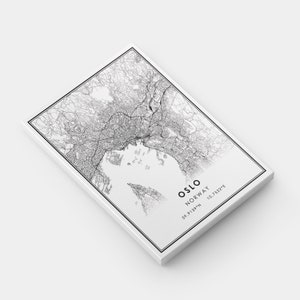 May include: Black and white line art map of Oslo, Norway. The map shows the city streets and surrounding area. The text "Oslo, Norway 59.9139&deg;N 10.7522&deg;E" is at the bottom of the map.