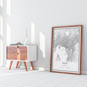 May include: A black and white line art print of a city map with the text "OSLO NORWAY 59.9139&deg;N 10.7522&deg;E" in a brown wood frame.