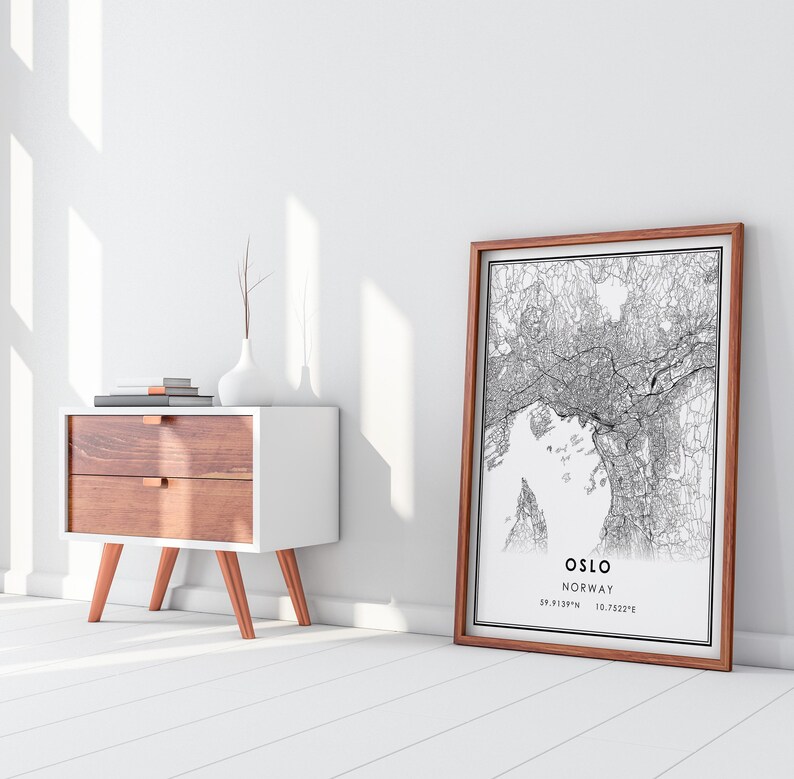 May include: A black and white line art print of a city map with the text "OSLO NORWAY 59.9139&deg;N 10.7522&deg;E" in a brown wood frame.
