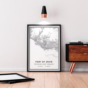 Puede incluir: Impresi&oacute;n de mapa de arte de l&iacute;nea en blanco y negro de Puerto Espa&ntilde;a, Trinidad y Tobago en un marco negro. La impresi&oacute;n incluye el nombre de la ciudad, el pa&iacute;s y las coordenadas. La impresi&oacute;n est&aacute; colgada en una pared blanca sobre una c&oacute;moda de madera.
