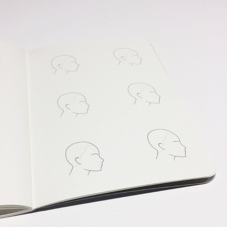 May include: A notebook page with six simple line drawings of a person's head in profile. The drawings are all the same size and are arranged in two rows of three.