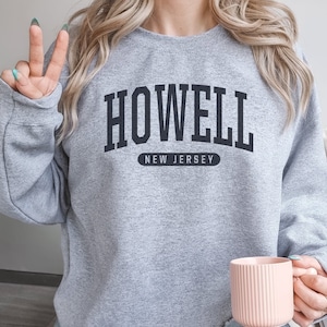 May include: Gray sweatshirt with black text that reads "HOWELL NEW JERSEY".