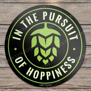May include: A black and green round sticker with the text "IN THE PURSUIT OF HOPPINESS" in a white circle with a green hop cone graphic in the center. The text "©207 THREADS" is at the bottom of the sticker.