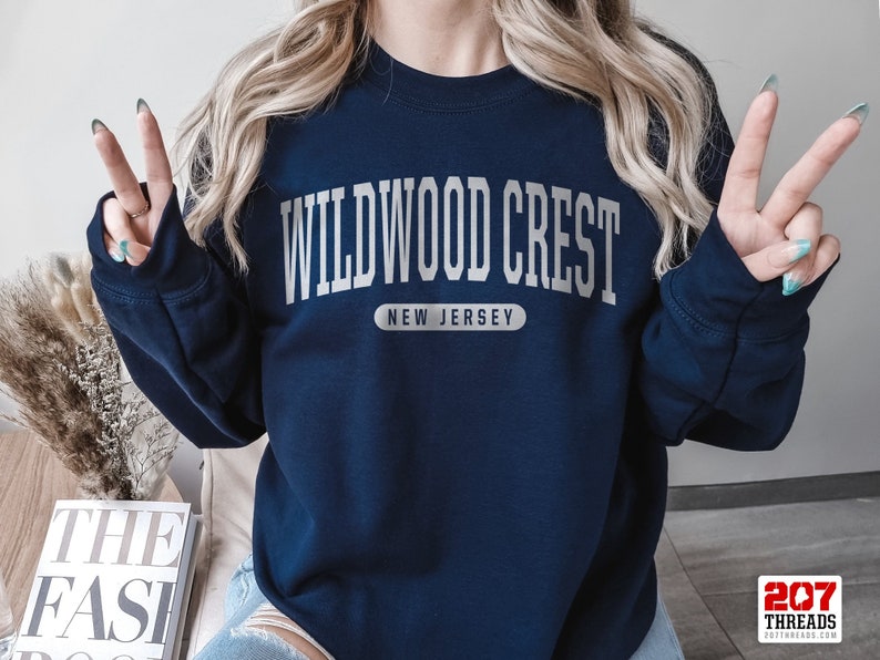 May include: A navy blue sweatshirt with the text "WILDWOOD CREST NEW JERSEY" in white lettering.