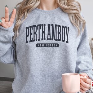 May include: A gray sweatshirt with black text that reads "Perth Amboy, New Jersey".