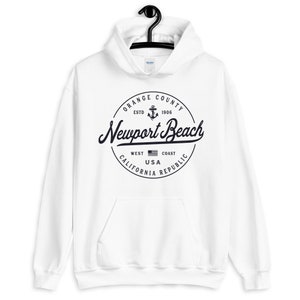 May include: White hoodie with a black circle graphic featuring the text "Orange County Est. 1906 Newport Beach West Coast USA California Republic" and an anchor symbol.