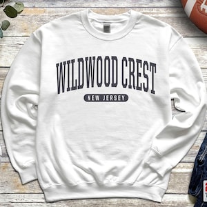 May include: White sweatshirt with a navy blue print that reads "Wildwood Crest, New Jersey".