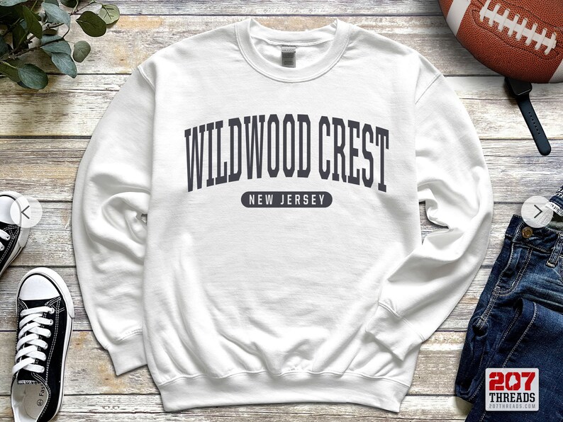 May include: White sweatshirt with a navy blue print that reads "Wildwood Crest, New Jersey".