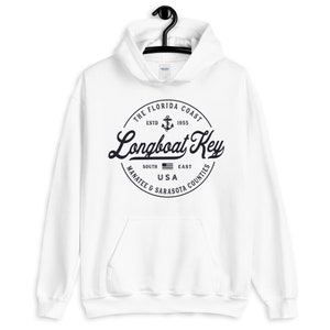 May include: White hoodie with a black and white circular graphic featuring the text "THE FLORIDA COAST ESTD 1955 Longboat Key SOUTH MANATEE & SARASOTA COUNTIES EAST USA".