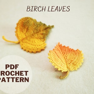 May include: Crochet pattern for two birch leaves in yellow and orange. The pattern is available as a PDF download. The text "PDF CROCHET PATTERN" is on a white circle.