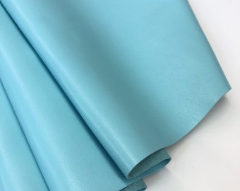 May include: A folded piece of light blue leather. The leather has a smooth, slightly textured surface.
