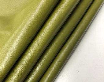 May include: Close-up of a folded piece of green leather. The leather has a smooth, slightly shiny surface.