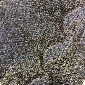 K&ouml;nnte beinhalten: Schwarzer Kunstlederstoff mit einem blauen und gr&uuml;nen Schlangenhautmuster.