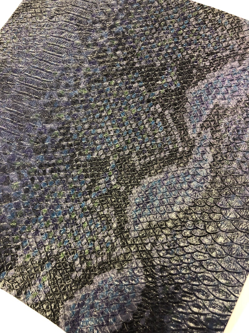 K&ouml;nnte beinhalten: Schwarzer Kunstlederstoff mit einem blauen und gr&uuml;nen Schlangenhautmuster.