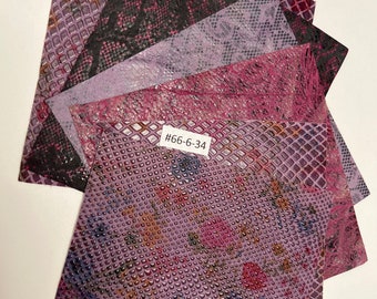 May include: A stack of five different patterned faux leather sheets in shades of purple, pink, and black. The top sheet has a textured, embossed pattern. The sheet below it has a snake skin pattern. The third sheet has a grid pattern. The fourth sheet has a subtle, textured pattern. The fifth sheet has a snake skin pattern. The label on the third sheet reads "#66-6-34".