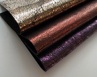 May include: Three pieces of faux leather in gold, copper, and purple with a cracked or textured surface.