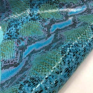 May include: Blue snakeskin fabric with a glossy finish. The fabric has a textured pattern that resembles snake scales.
