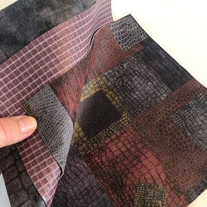 May include: A set of three patterned fabric samples. The top sample is a dark gray with a subtle texture. The middle sample is a light purple with a grid pattern. The bottom sample is a multi-colored patchwork of brown, red, and black with a crocodile skin pattern.