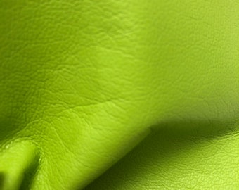 May include: Close-up of a bright green leather fabric with a textured surface.