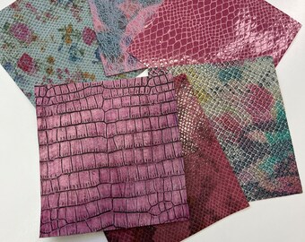 May include: A collection of six faux leather sheets in various patterns and colors, including pink, green, and brown. The sheets have a textured, reptile-like pattern.