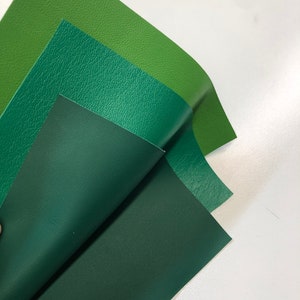 May include: Three pieces of green faux leather in different shades of green. The leather is textured and has a slight sheen.
