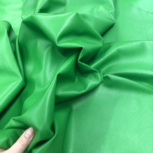 May include: A piece of bright green leather, folded and draped, showing the texture and color of the material.