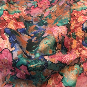 May include: Abstract fabric with a colorful watercolor-like pattern in shades of pink, blue, green, and brown.