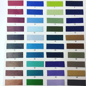 May include: A color chart with 36 different leather swatches. The swatches are arranged in rows of four, with each row numbered 1-9. The swatches are a variety of colors, including red, blue, green, brown, and gray.